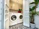 A modern laundry room has black and white patterned floors, and white cabinets for ample storage at 10120 E Topaz Dr, Scottsdale, AZ 85258