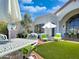 Outdoor patio with white iron furniture, umbrellas, manicured lawn, and elegant exterior at 10120 E Topaz Dr, Scottsdale, AZ 85258