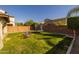 Spacious backyard featuring a trampoline, play structure, lush lawn, and a privacy wall for added seclusion at 10129 E Ampere Ave, Mesa, AZ 85212