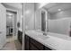 Well-lit bathroom featuring a white countertop, dark cabinets, and convenient laundry access at 10129 E Ampere Ave, Mesa, AZ 85212