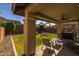 Inviting covered patio with comfortable seating, offering a relaxing view of the lush backyard and surrounding landscape at 10129 E Ampere Ave, Mesa, AZ 85212