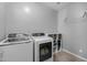 Bright laundry room featuring a modern washer, dryer, storage, and a convenient hanging rack for clothes at 10129 E Ampere Ave, Mesa, AZ 85212