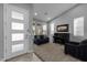 Cozy living room featuring a piano, sofa, and a large window for natural light at 10129 E Ampere Ave, Mesa, AZ 85212