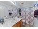 Bathroom with single vanity, shower/tub combo, and patterned curtain at 11849 N 51St Dr, Glendale, AZ 85304