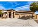 Tan one-story house with a three-car garage and desert landscaping at 13756 W Watson Ln, Surprise, AZ 85379