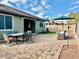 Outdoor brick patio with dining set, umbrella, and lounge seating offers perfect entertaining and relaxation space at 15704 W Taylor St, Goodyear, AZ 85338