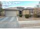 Inviting single-story home featuring a two-car garage and arched entryway, set amidst well-maintained landscaping at 15704 W Taylor St, Goodyear, AZ 85338