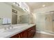 Double vanity bathroom with large shower and mirror at 16331 W Willow Creek Ln, Surprise, AZ 85374