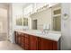 Bathroom with dual sinks, wood cabinetry, and a large mirror at 16331 W Willow Creek Ln, Surprise, AZ 85374