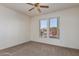 Bedroom with two windows, a ceiling fan, and carpeted floors at 16331 W Willow Creek Ln, Surprise, AZ 85374