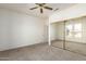 Bedroom with mirrored closet doors and ceiling fan at 16331 W Willow Creek Ln, Surprise, AZ 85374