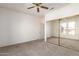 Carpeted bedroom with sliding mirror closet door and ceiling fan at 16331 W Willow Creek Ln, Surprise, AZ 85374