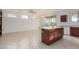 Bright kitchen featuring an island with a white countertop, wood cabinets, and modern appliances at 16331 W Willow Creek Ln, Surprise, AZ 85374