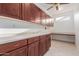 Laundry room featuring wood cabinets, tile floor, and long countertop at 16331 W Willow Creek Ln, Surprise, AZ 85374