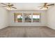 Spacious living room with large windows and ceiling fans at 16331 W Willow Creek Ln, Surprise, AZ 85374