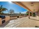 Spacious backyard patio with built-in grill and ceiling fans at 16331 W Willow Creek Ln, Surprise, AZ 85374