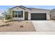 New construction home with a two-car garage and desert landscaping at 17735 W Mission Ln, Waddell, AZ 85355