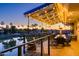 Evening view of a covered patio with string lights, table, chairs, and lake view at 1841 E Augusta Ave, Chandler, AZ 85249