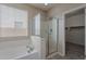 Bright bathroom featuring a glass shower, soaking tub beneath a window, and neutral tones at 1851 W Pelican Dr, Chandler, AZ 85286