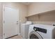 Well-lit laundry room with modern washer and dryer, and ample shelving space at 1851 W Pelican Dr, Chandler, AZ 85286