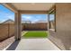 Covered back patio leading to a low-maintenance backyard featuring artificial turf and gravel at 18819 W Cholla St, Surprise, AZ 85388