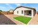 Low-maintenance backyard featuring artificial turf and gravel, plus a covered patio at 18819 W Cholla St, Surprise, AZ 85388