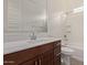 A well-lit bathroom features a vanity with wood cabinets, a white countertop and a shower-tub combo at 18819 W Cholla St, Surprise, AZ 85388