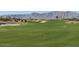 Expansive green golf course with sand traps and mountain views, perfect for golf enthusiasts and outdoor activities at 18819 W Cholla St, Surprise, AZ 85388