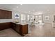 This open kitchen features wood cabinets, an island with a sink, and is virtually staged for living and dining at 18819 W Cholla St, Surprise, AZ 85388