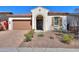 Single-story home with Spanish-style architecture, featuring a two-car garage and landscaped front yard at 20508 W Carlton Mnr Mnr, Buckeye, AZ 85396