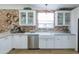 Modern kitchen features white cabinets, a farmhouse sink and exposed brick wall at 2111 W Mulberry Dr, Phoenix, AZ 85015