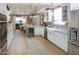 Open concept kitchen with white cabinets, a farmhouse sink, and exposed brick at 2111 W Mulberry Dr, Phoenix, AZ 85015