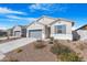 Single-story home boasts a gray stucco exterior, desert landscaping, gray garage door, and inviting curb appeal at 2530 W Sable Ave, Apache Junction, AZ 85120