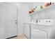 This laundry room features a white washer and dryer, plus shelving for storage at 2530 W Sable Ave, Apache Junction, AZ 85120