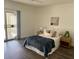 Bright bedroom with a queen bed, wood floors, nightstands, and sliding glass door access to the outside at 2571 N Miller Rd, Scottsdale, AZ 85257