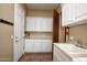 Bright laundry room with white cabinets, sink, and tile floor at 26293 W Sierra Pinta Dr, Buckeye, AZ 85396