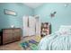 Light teal bedroom with twin bed, dresser, and shelving at 2702 S Joplin --, Mesa, AZ 85209