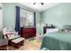 Light green bedroom with twin bed, rocking chair, and dresser at 2702 S Joplin --, Mesa, AZ 85209