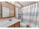 Simple bathroom with wood vanity, shower, and striped curtain at 2725 E Mine Creek Rd # 2054, Phoenix, AZ 85024