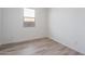 Bright bedroom with neutral walls and wood-look flooring, featuring a window at 2811 N 212Th Dr, Buckeye, AZ 85396