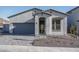 Single-story home with gray exterior, two-car garage, and landscaped front yard at 2811 N 212Th Dr, Buckeye, AZ 85396