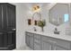 Double vanity bathroom with gray cabinets, hexagon mirrors, and geometric tile floor at 3020 E Lark Dr, Chandler, AZ 85286