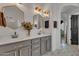 Double vanity bathroom with gray cabinets, hexagon mirrors, and geometric tile floor at 3020 E Lark Dr, Chandler, AZ 85286