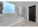 Modern bathroom with soaking tub, glass shower, and geometric tile floor at 3020 E Lark Dr, Chandler, AZ 85286