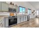 Modern kitchen with gray cabinets, stainless steel appliances, and wood flooring at 3020 E Lark Dr, Chandler, AZ 85286