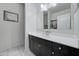 Modern bathroom vanity with a white countertop, dark wood cabinets, and decorative mirror at 30263 W Pinchot Ave, Buckeye, AZ 85396