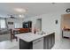 Kitchen island with a sink, dishwasher, and breakfast bar open to dining and living areas at 30263 W Pinchot Ave, Buckeye, AZ 85396