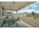 Covered patio with green metal table and chairs overlooking a private, gravel backyard at 30263 W Pinchot Ave, Buckeye, AZ 85396