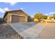 Exterior view of a two-car garage and long driveway with desert landscaping and a clear blue sky at 3102 W Louise Dr, Phoenix, AZ 85027