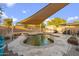 Beautiful swimming pool with a sunshade, BBQ, and desert landscaping, perfect for outdoor entertaining at 3102 W Louise Dr, Phoenix, AZ 85027